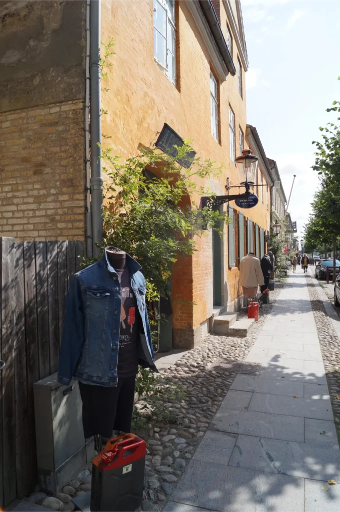 Hos Birger, fysisk butik i Christiansfeld, set udefra med jeansjakke på en dukke